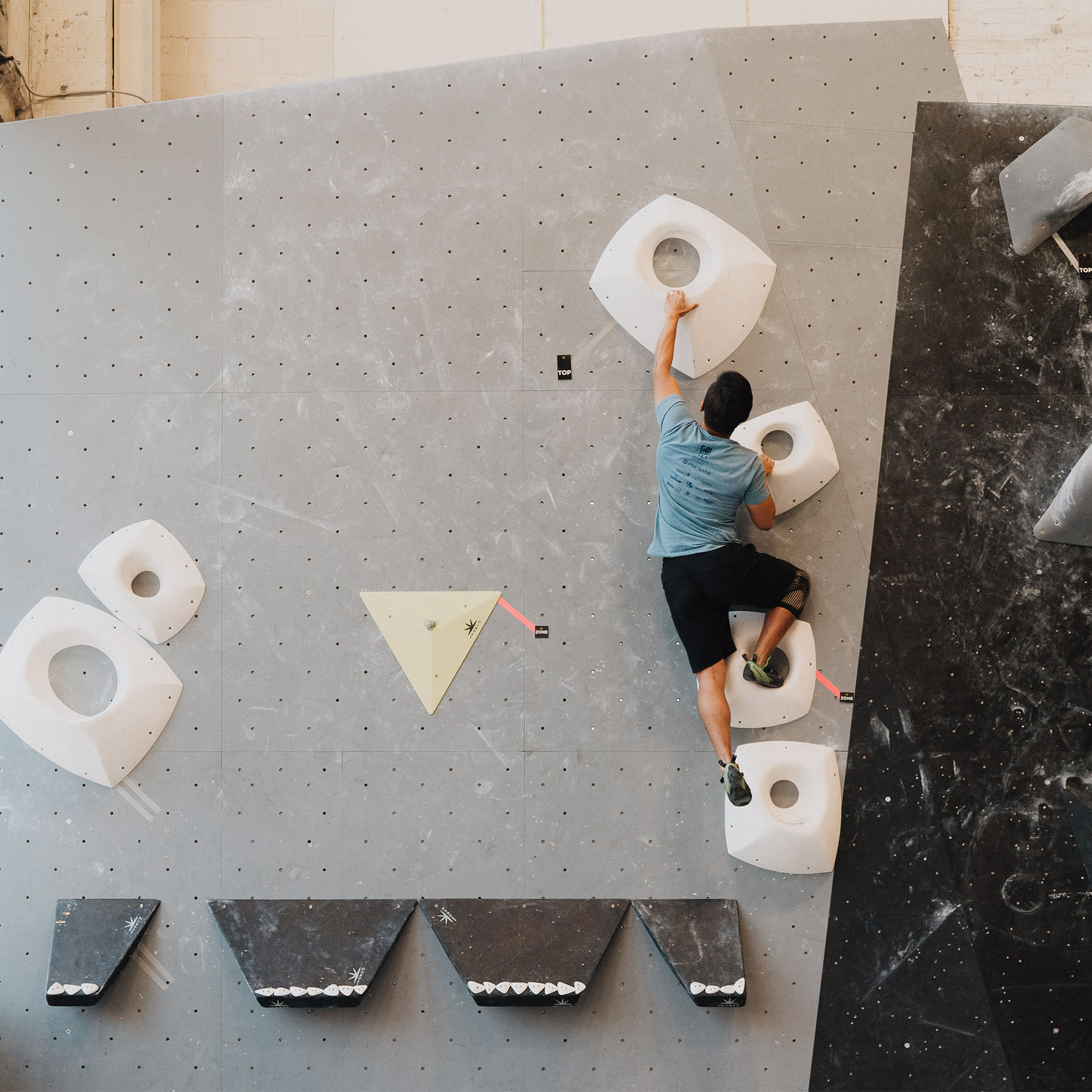 Person bouldering in a climbing gym.