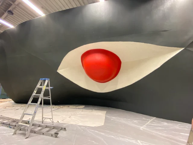 The journey of the Eye Wall is a bit of a hot mess. But that’s the beauty of any good story.

This one started at the Mammut Summer Games in Salt Lake City in 2009. Then traveled roughly 1,300 miles from SLC to STL. Of course, we were crazy enough to purchase it before we had even secured a building.

At the time, it was really just fiberglass and steel. But to us, it meant something much bigger. It was the first time art and climbing really intersected for us. We knew it needed to be part of our story.

Before it ever made it into the gym, we personally moved that wall three separate times between different storage units… loading and unloading it in the HOT Missouri heat. And somehow, every move felt a little more EPIC than the last.

As construction on the building started coming to an end, the Eye Wall finally found its home in 2012.

With one final move left, there was really only one question…

How the heck were we going to get that giant eyeball through the doors? 

—Dave Chancellor